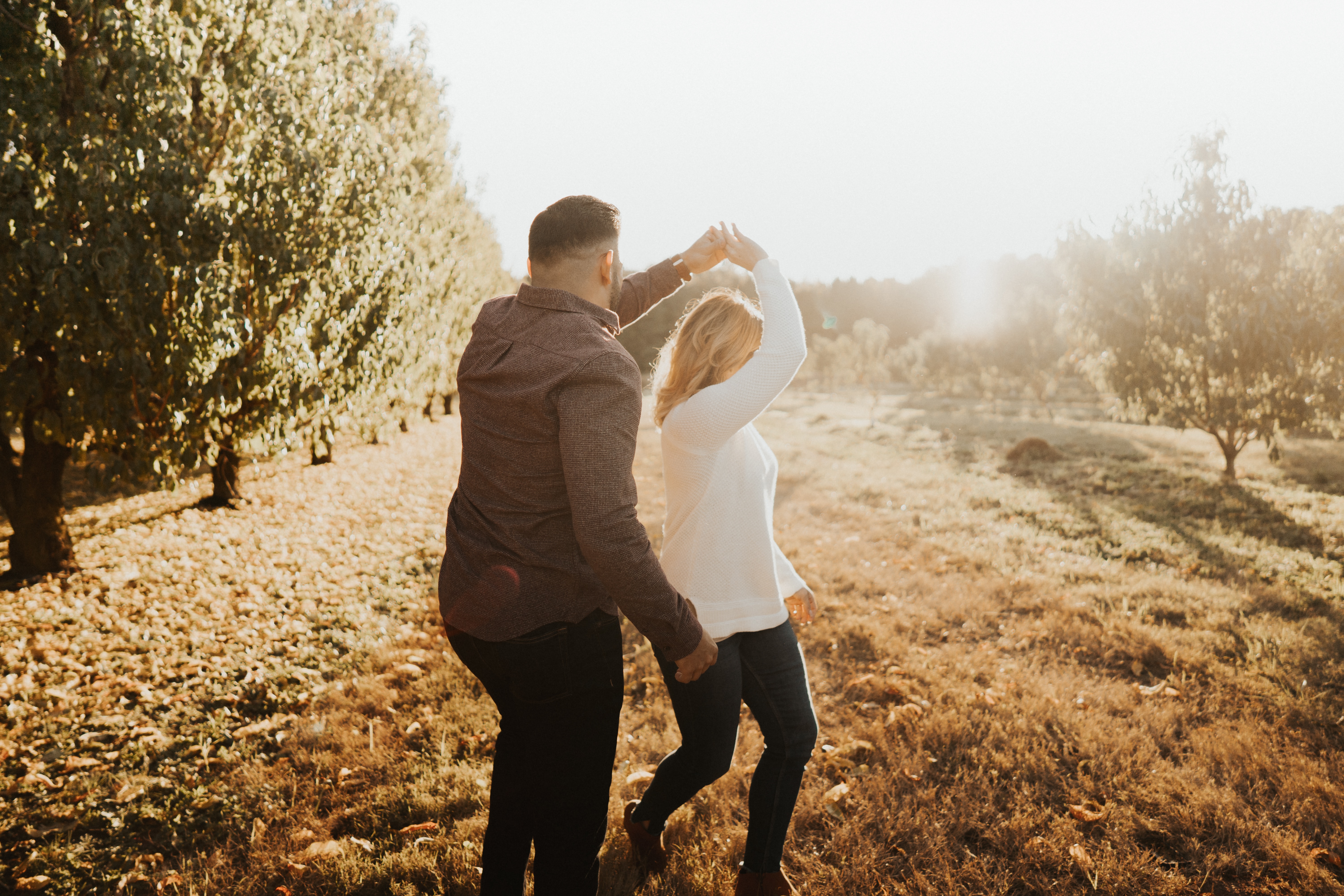 A couple happily dancing in a field after finding true love after 40.