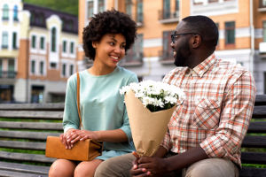 Young couple sitting next to each other on a bench.
