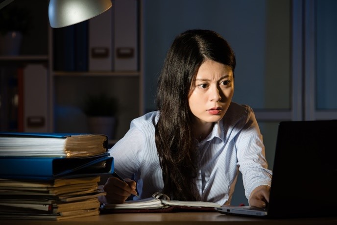 Woman working on her computer late into the night.