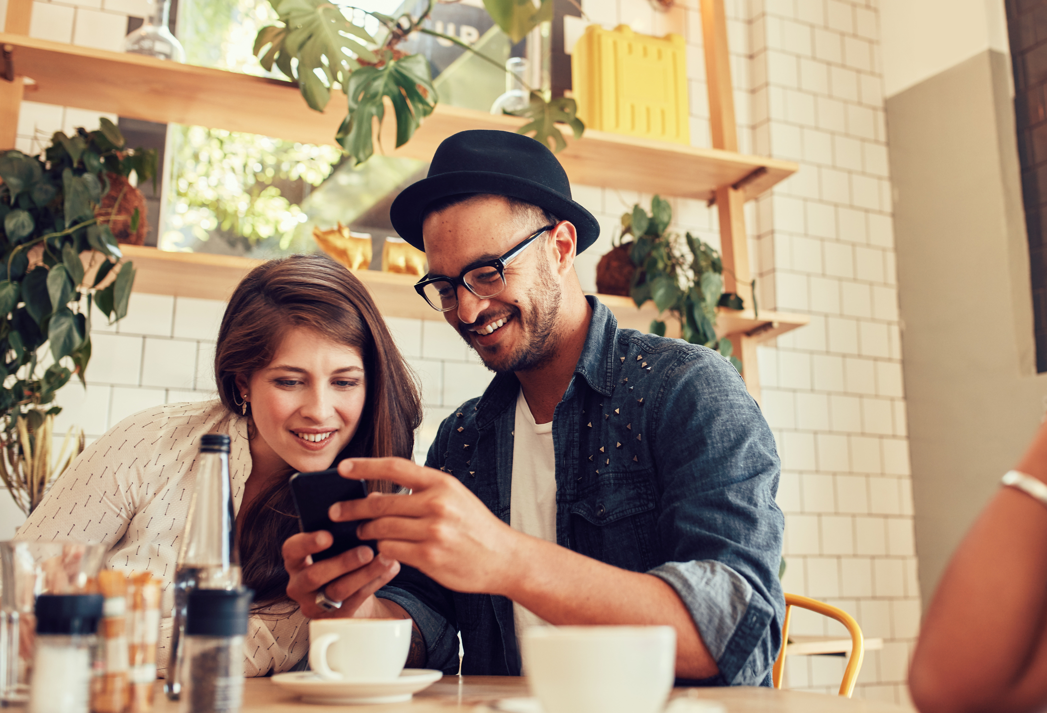 Guy and gal friends looking at a post over coffee.