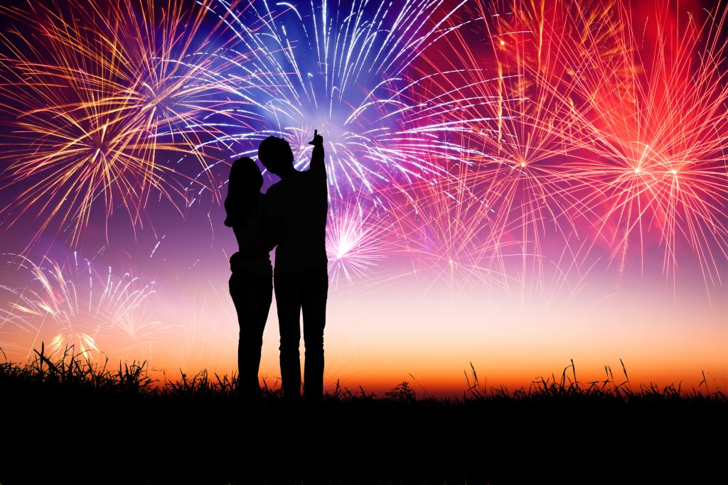 A couple embracing and watching fireworks.