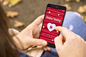 Woman looking at her online dating app on her phone during cuffing season.