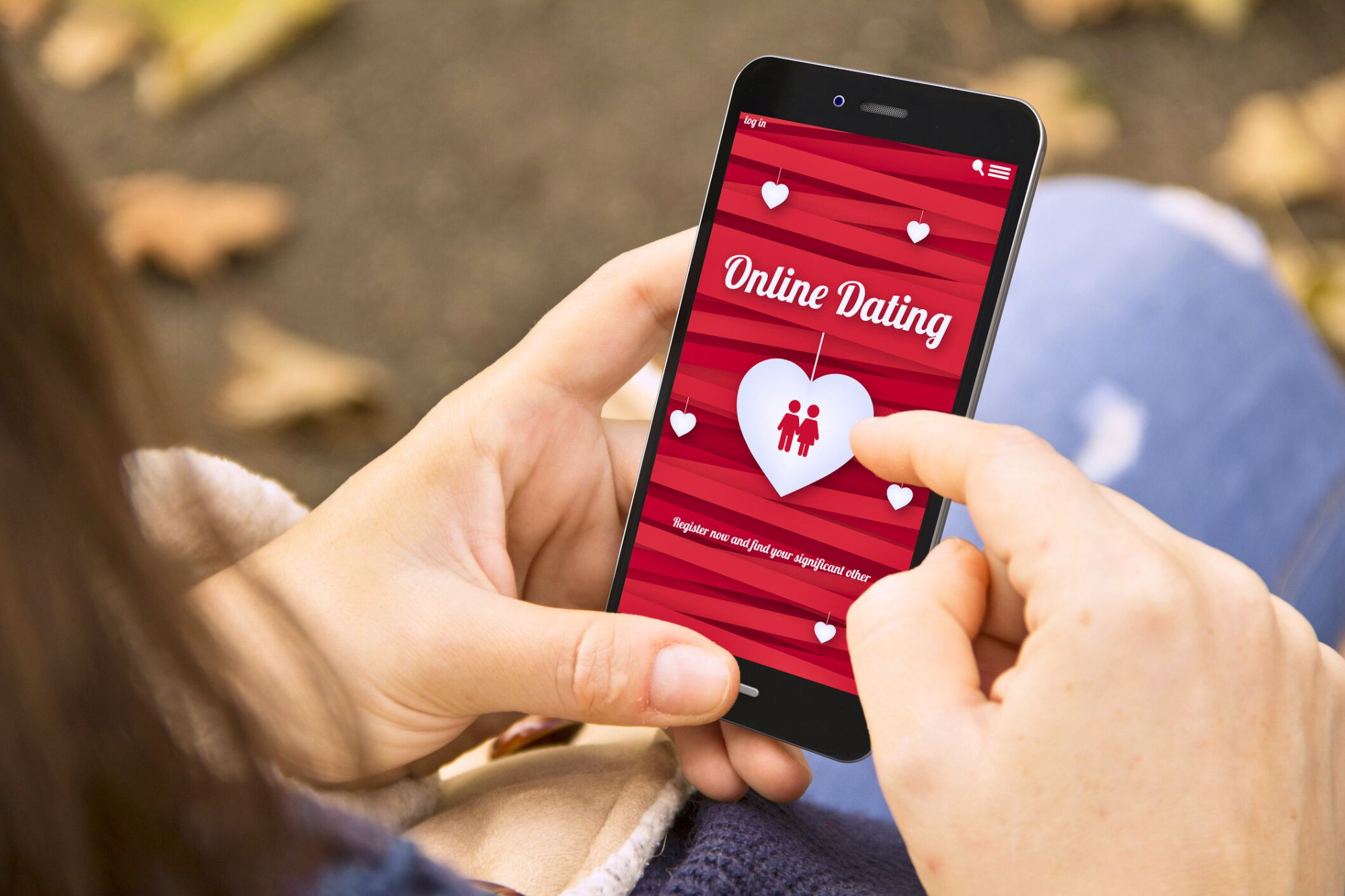 Woman looking at her online dating app on her phone during cuffing season.