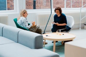 Women sitting in a comfortable room discussing what does a dating coach do.