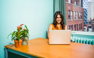 Woman at her laptop researching how to find a dating coach.