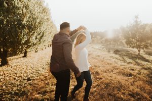 A couple happily dancing in a field after finding true love after 40.