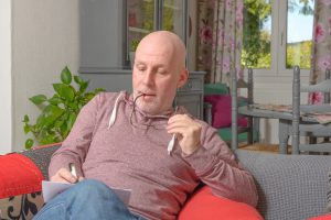 Man sitting on his couch working on his dating plan for finding true love.