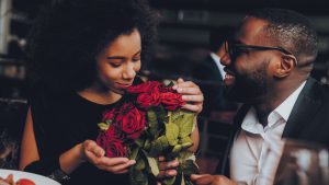 Single man over 40 giving beautiful red roses to his date.