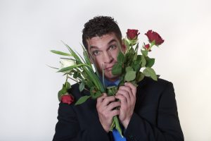 Man who is holding a bouquet of broken roses and finding true love difficult.