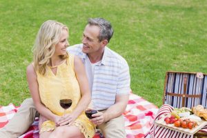 Man and woman cuddling while sharing a summer picnic.