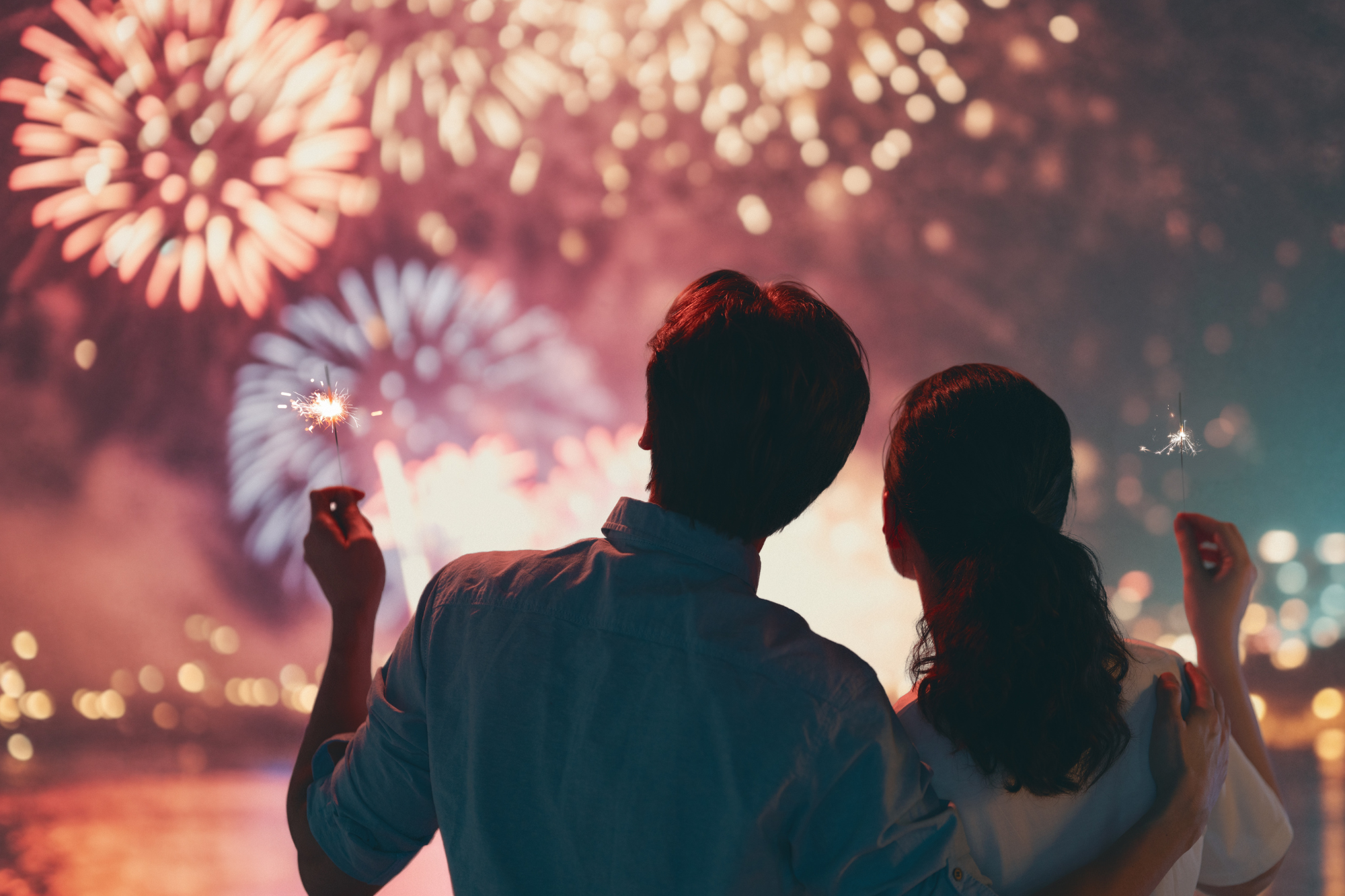 A couple choosing love while embracing and watching fireworks.