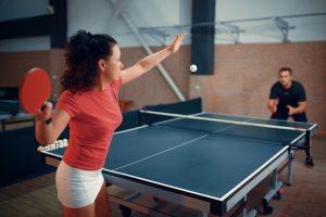 Couple fiercely competing in a game of table tennis.