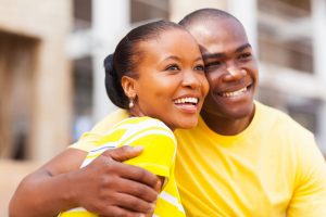 Couple wearing matching yellow t-shirts hugging in celebration of National True Love Day.