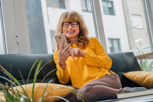 Over 50 year old woman using her phone for online dating.