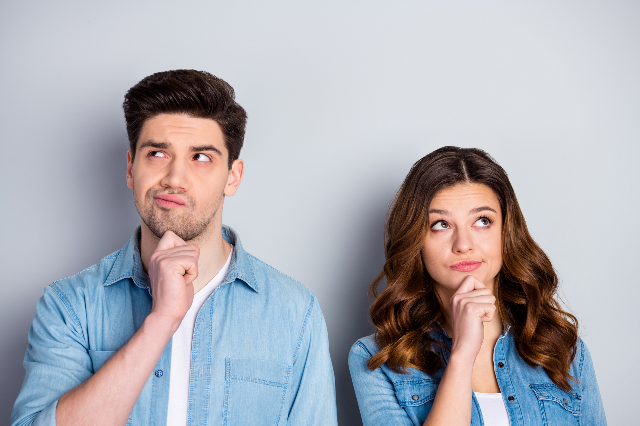 Couple in a new relationship standing next to each other and looking unsure.