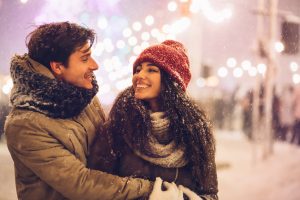 Couple at a winter celebration smiling at each other and basking in the joy of finding love again