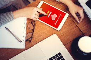 A woman, seeking a marriage partner, using her tablet to access marriage-minded dating sites.