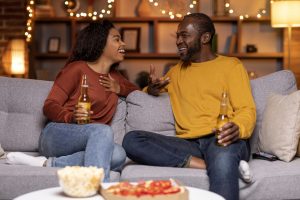 Couple sitting on a couch talking about their new relationship.