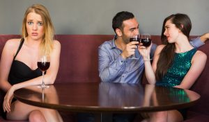Woman feeling uncomfortable because she's sitting next to a couple in true love.