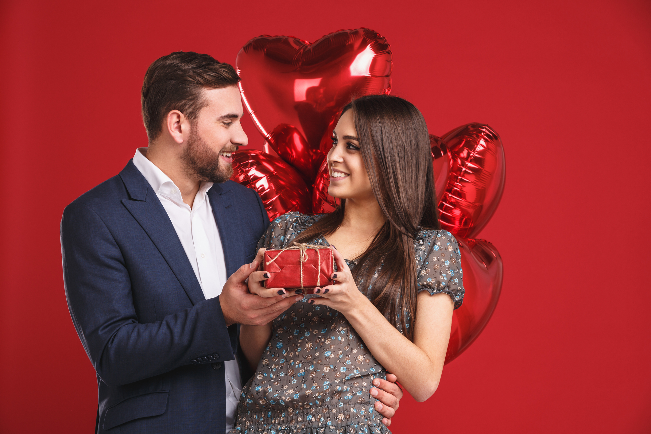A Guy who planned valentine's day giving his gal a present.