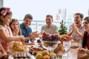A family sitting around the table with their single friends during the holidays.