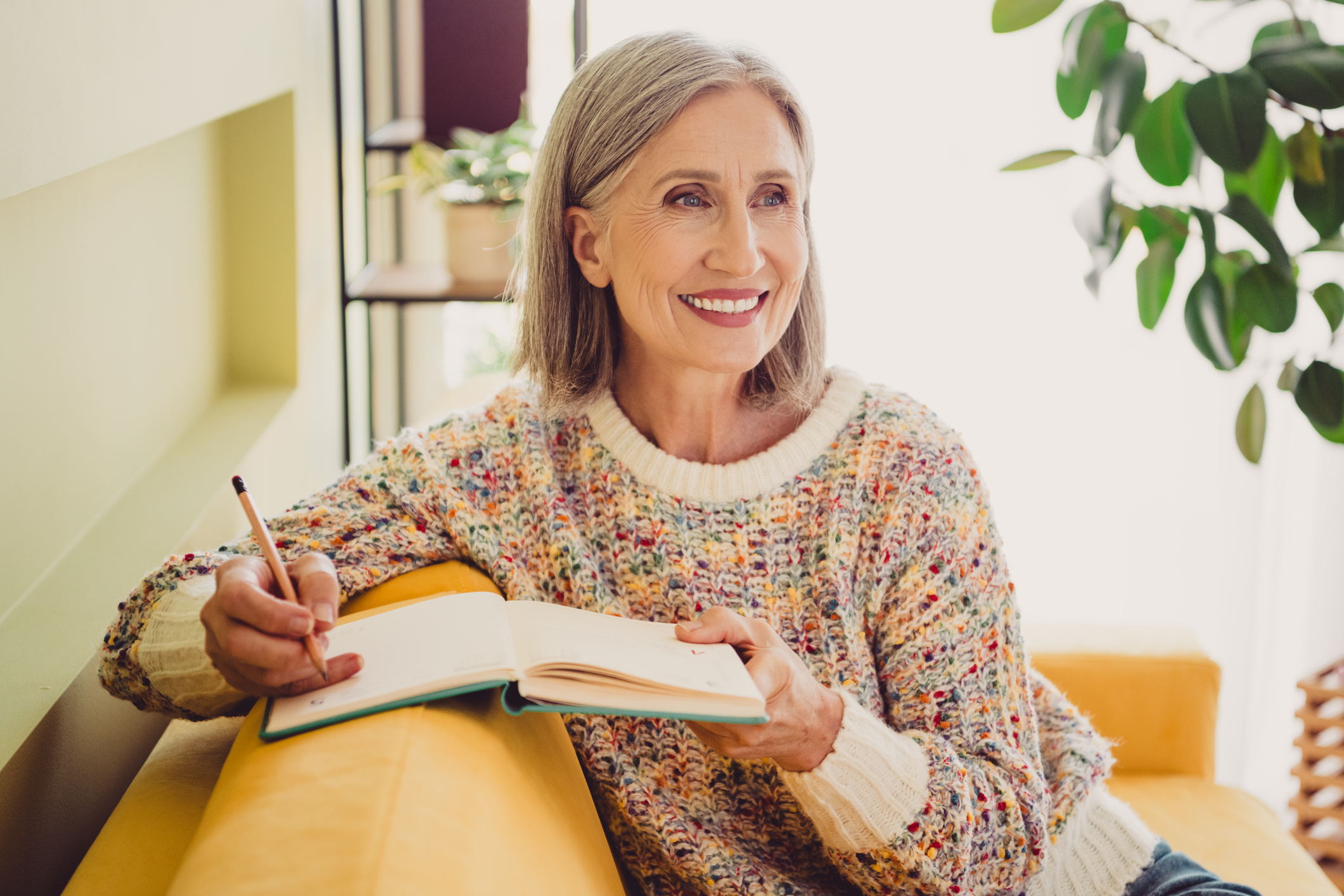 Woman is writing a list of things to be grateful for as she focuses on staying positive during the holidays.
