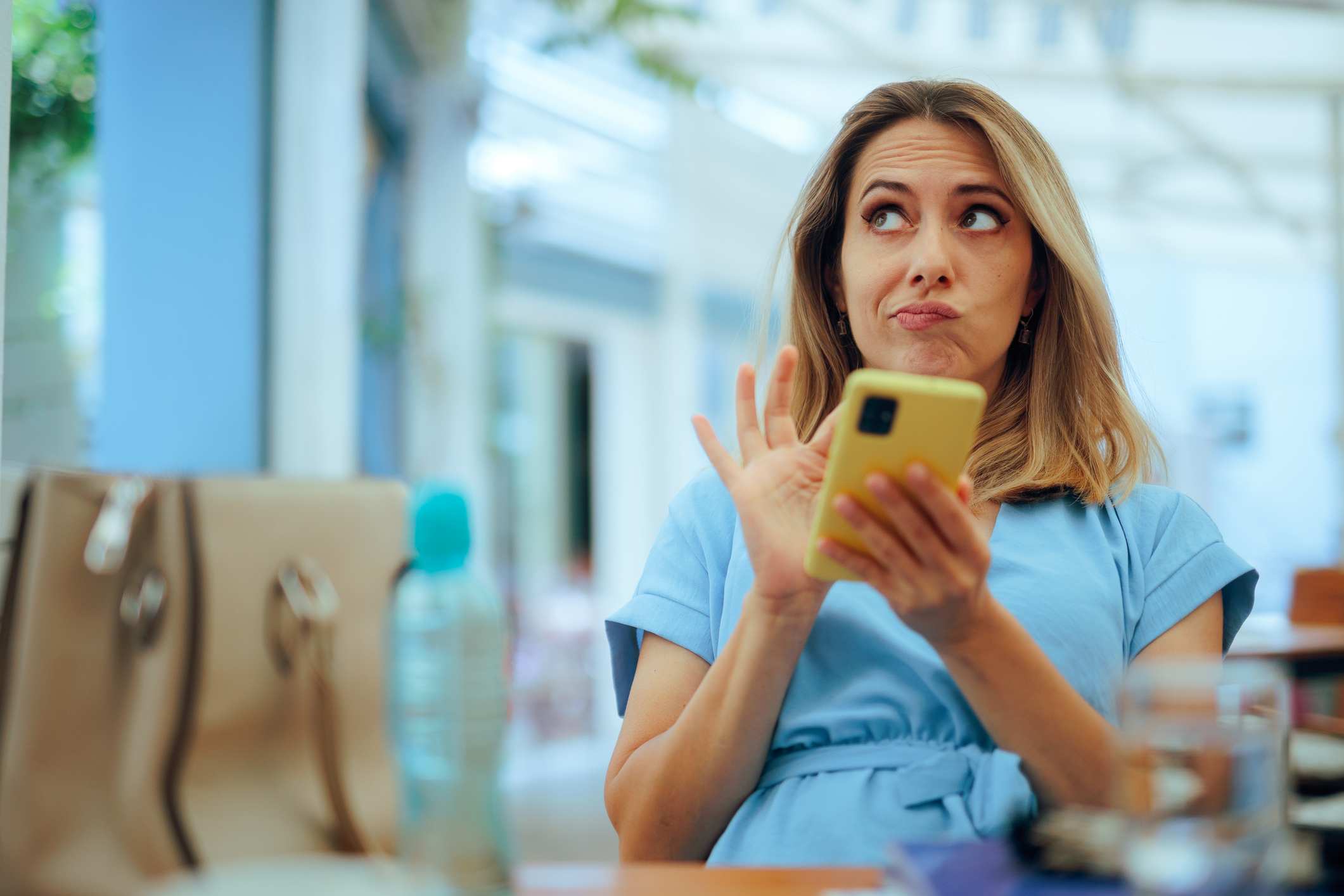 A confused woman in blue is sitting alone and jumping to conclusions about a potential romantic partner she met online.